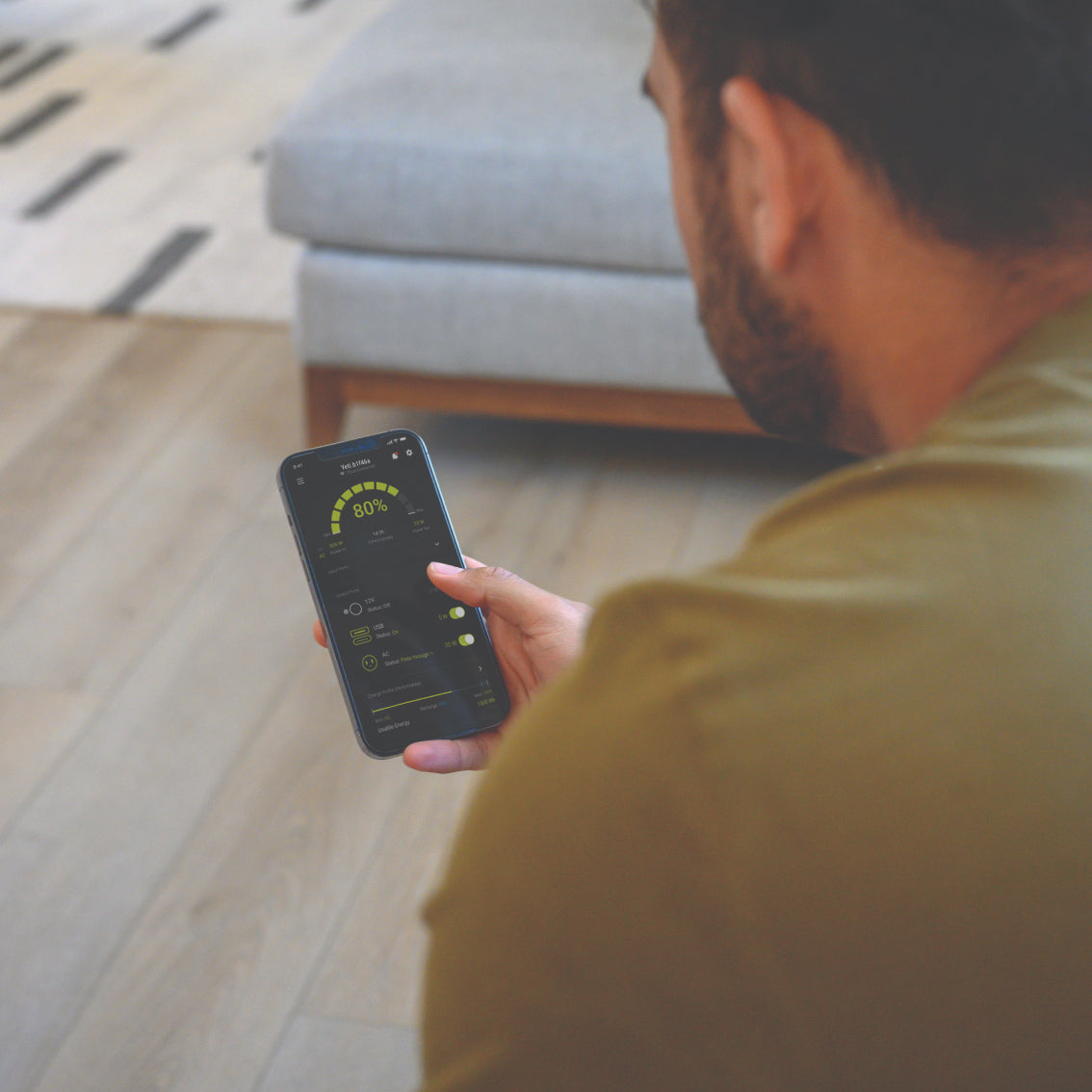 Person using the Goal Zero Power app on a phone in their living room